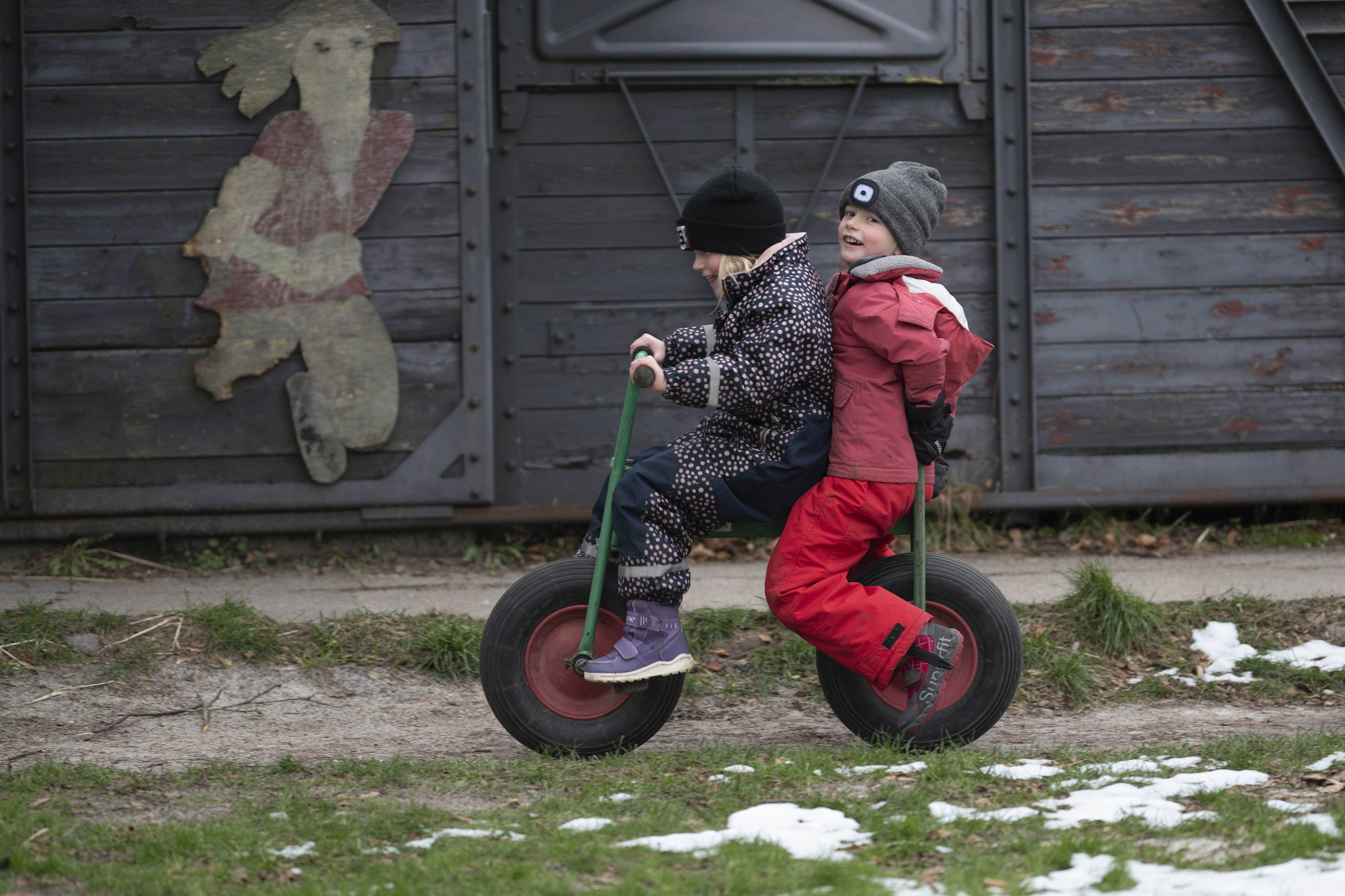 To piger cykler sammen på legepladsen