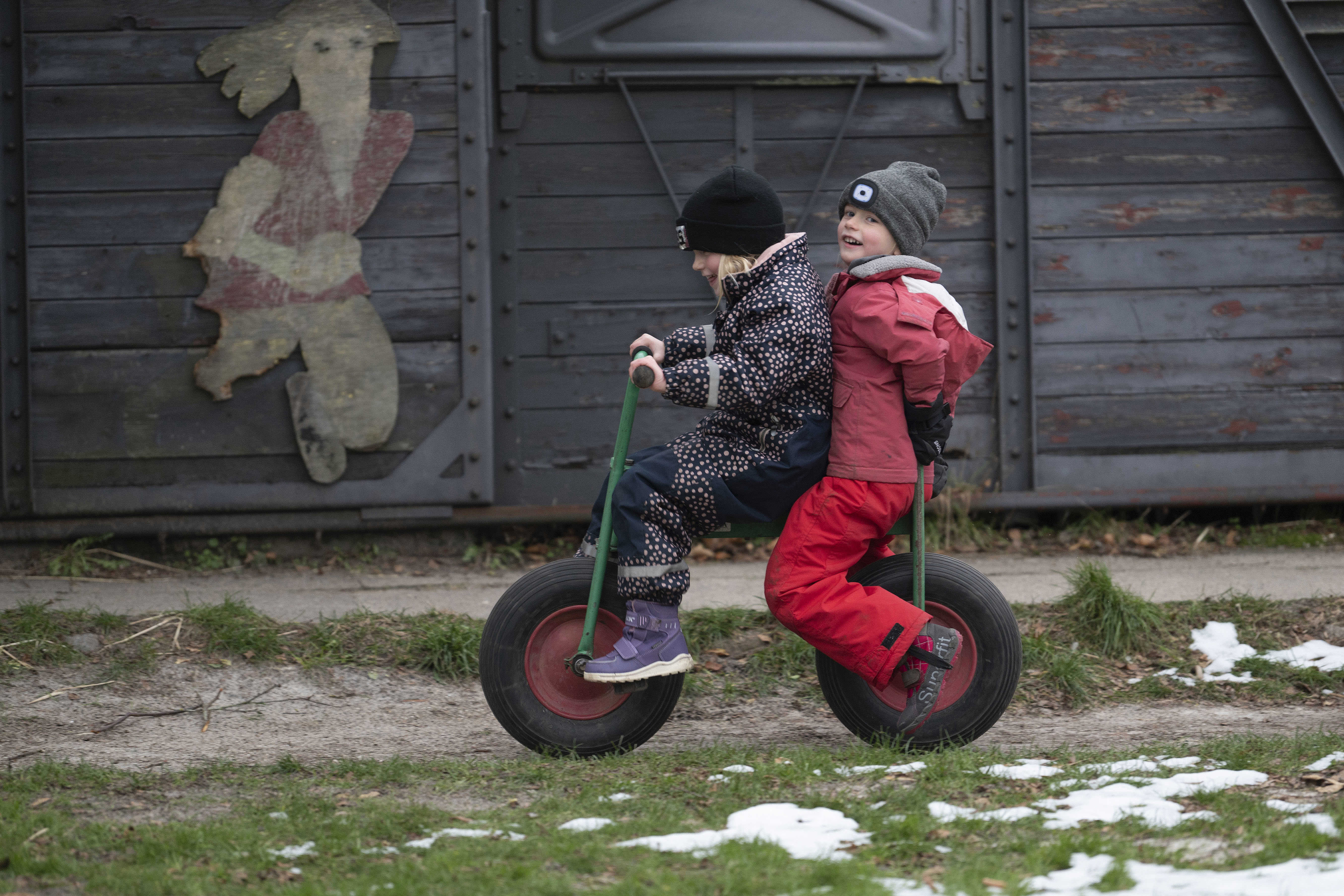 To piger cykler sammen på legepladsen