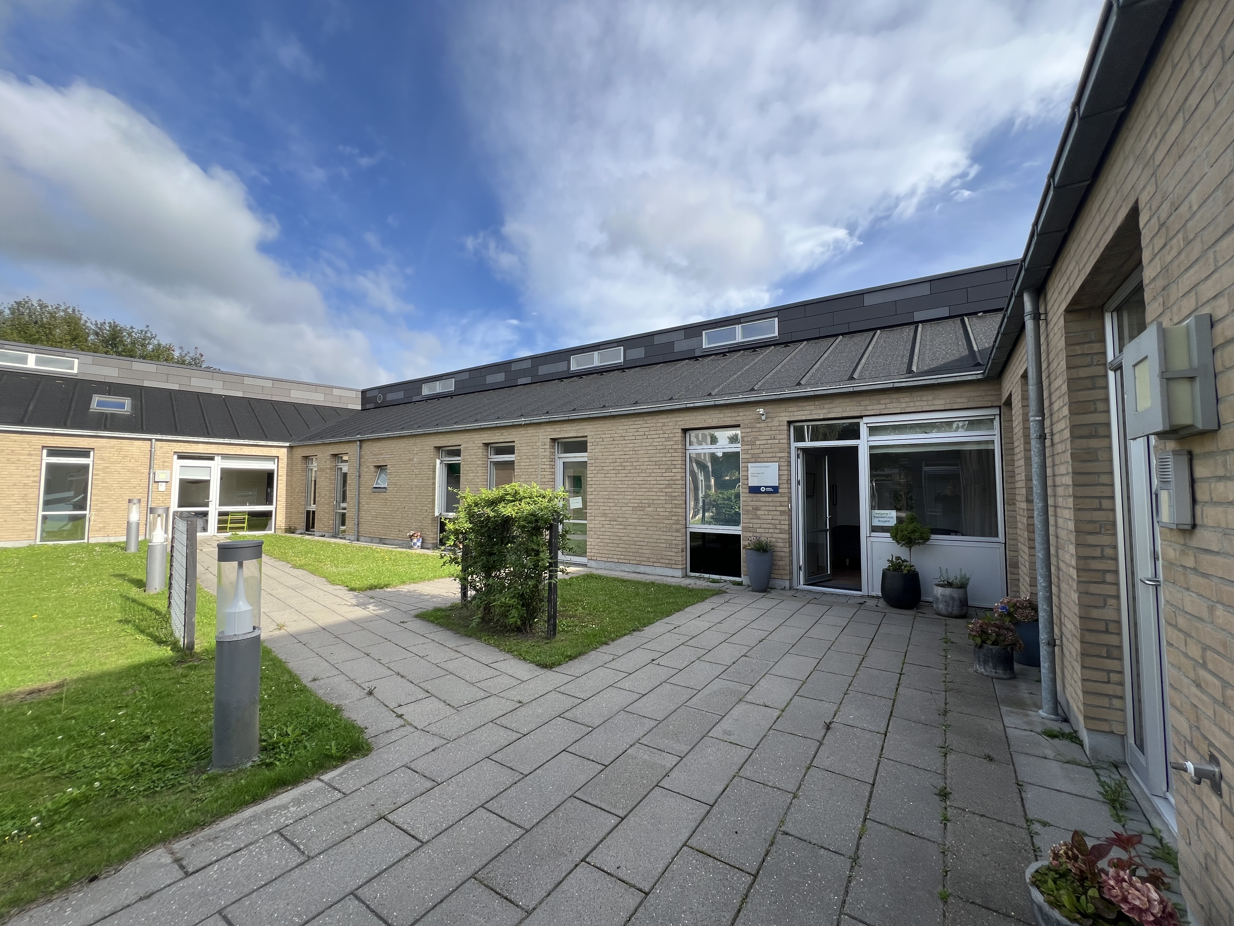 Familiehuset Bisgård Udefra med græsplæne og terrasse