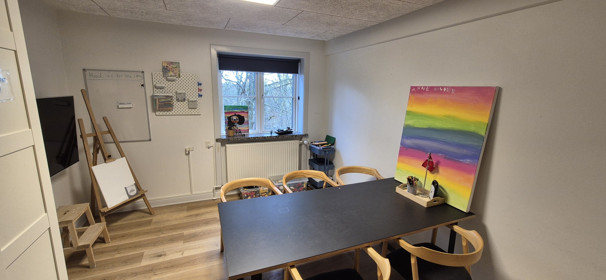 Krearum med arbejdsbord, farver og staffeli