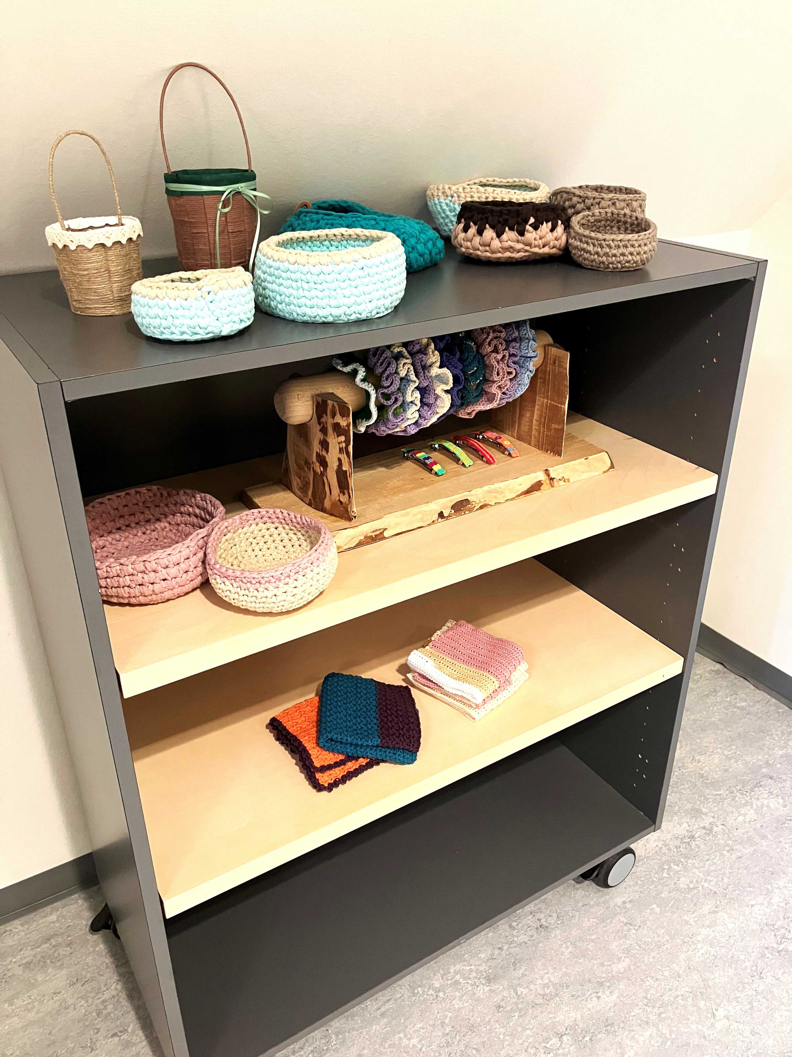 Grå reol med hjemmelavede kurve og hårbånd fra Værkstedet