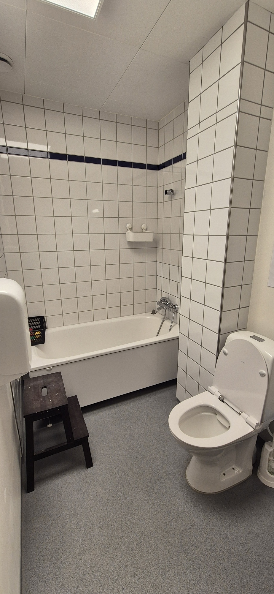 Badeværelse ned hvide fliser, toilet og badekar