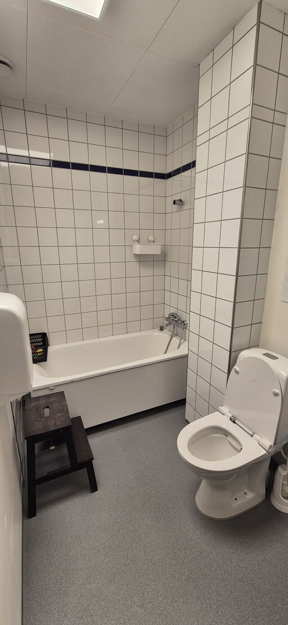 Badeværelse ned hvide fliser, toilet og badekar