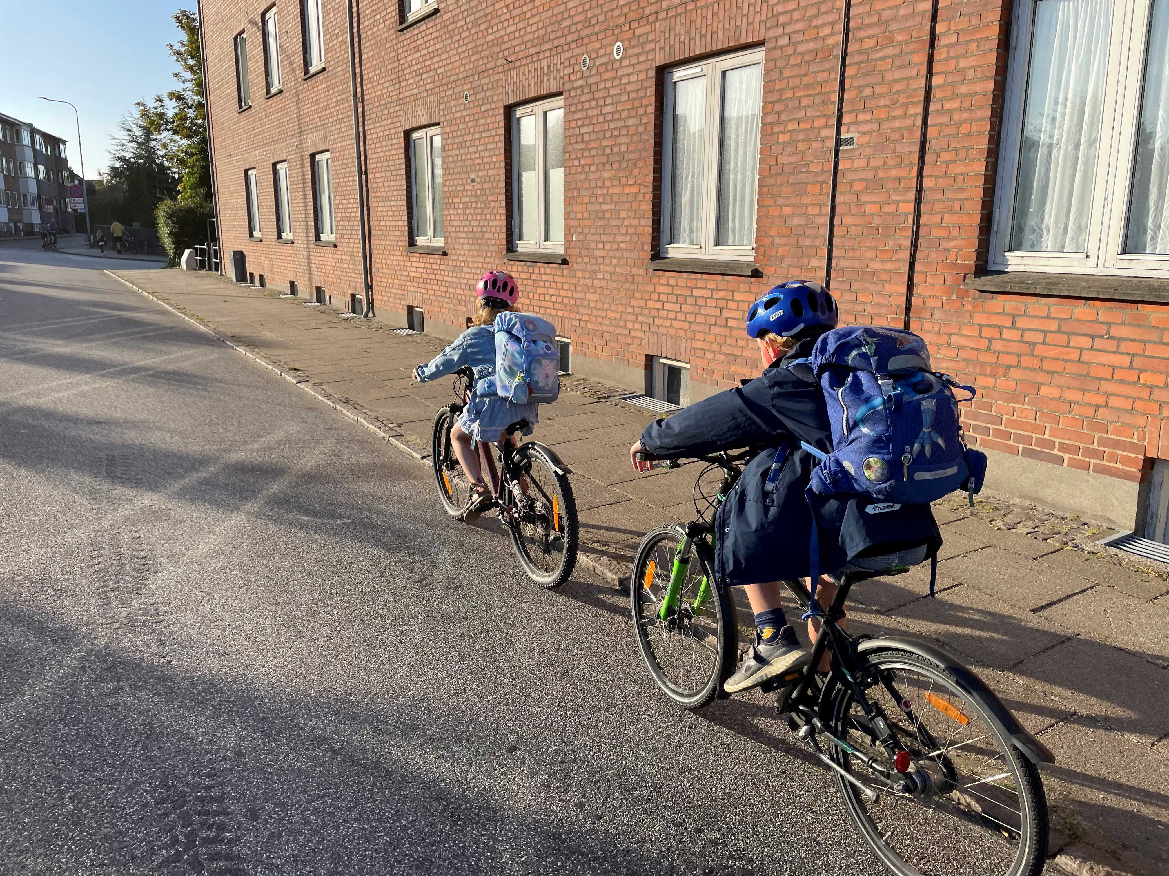 To børn der cykler i et bymiljø.
