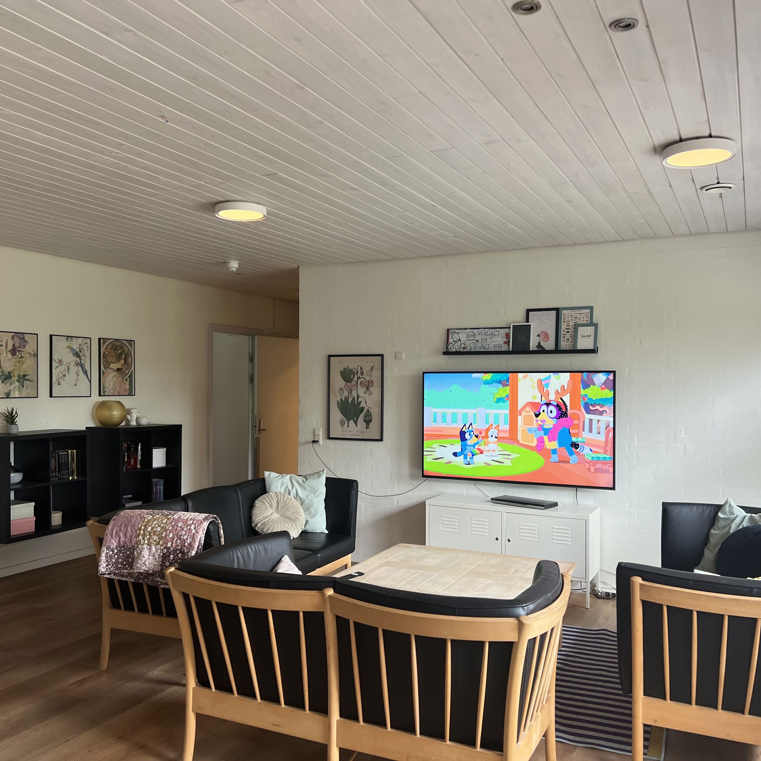 Vokseværket Fællesstue med tv, sofagruppe og reol