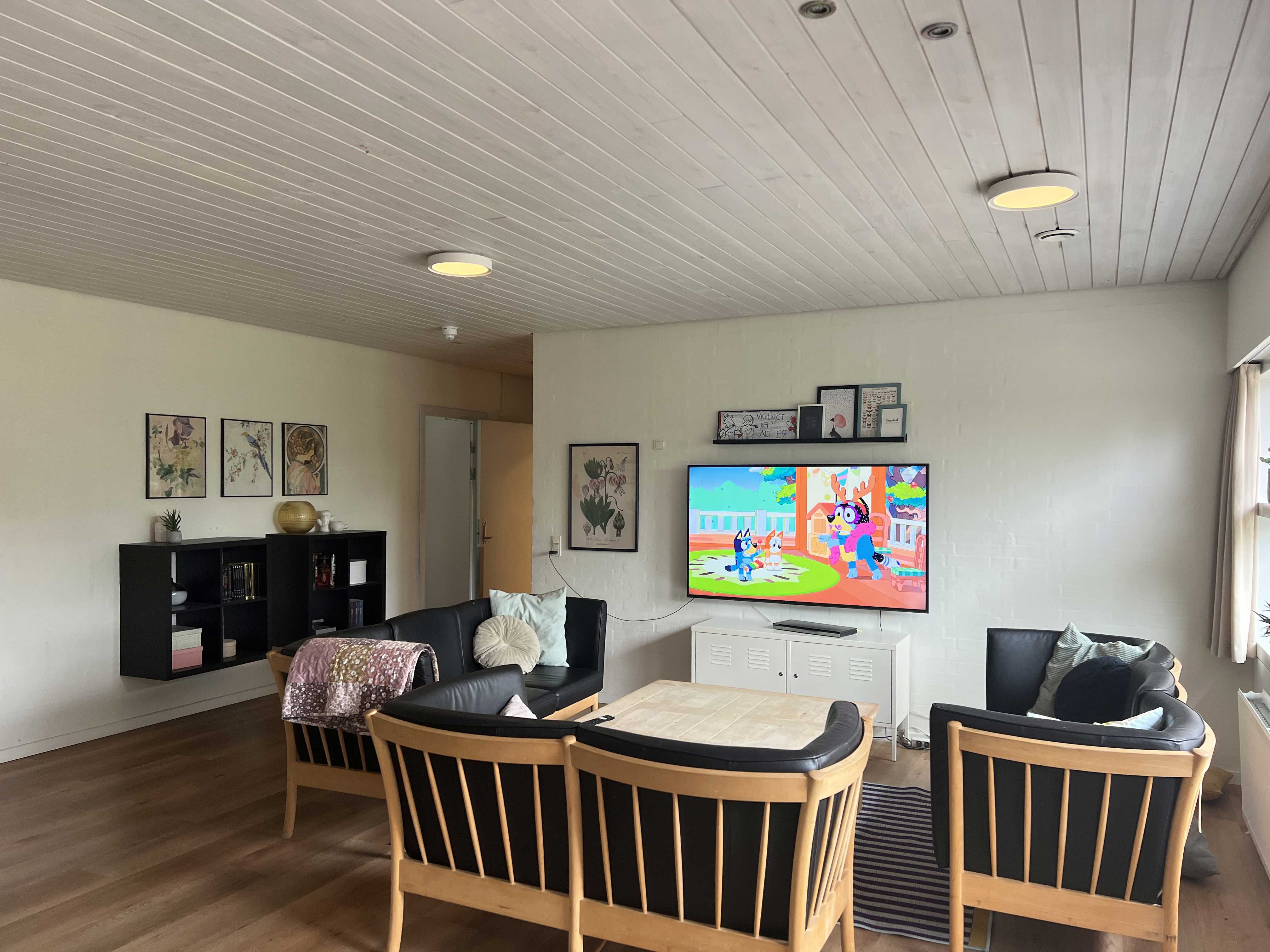 Vokseværket Fællesstue med tv, sofagruppe og reol