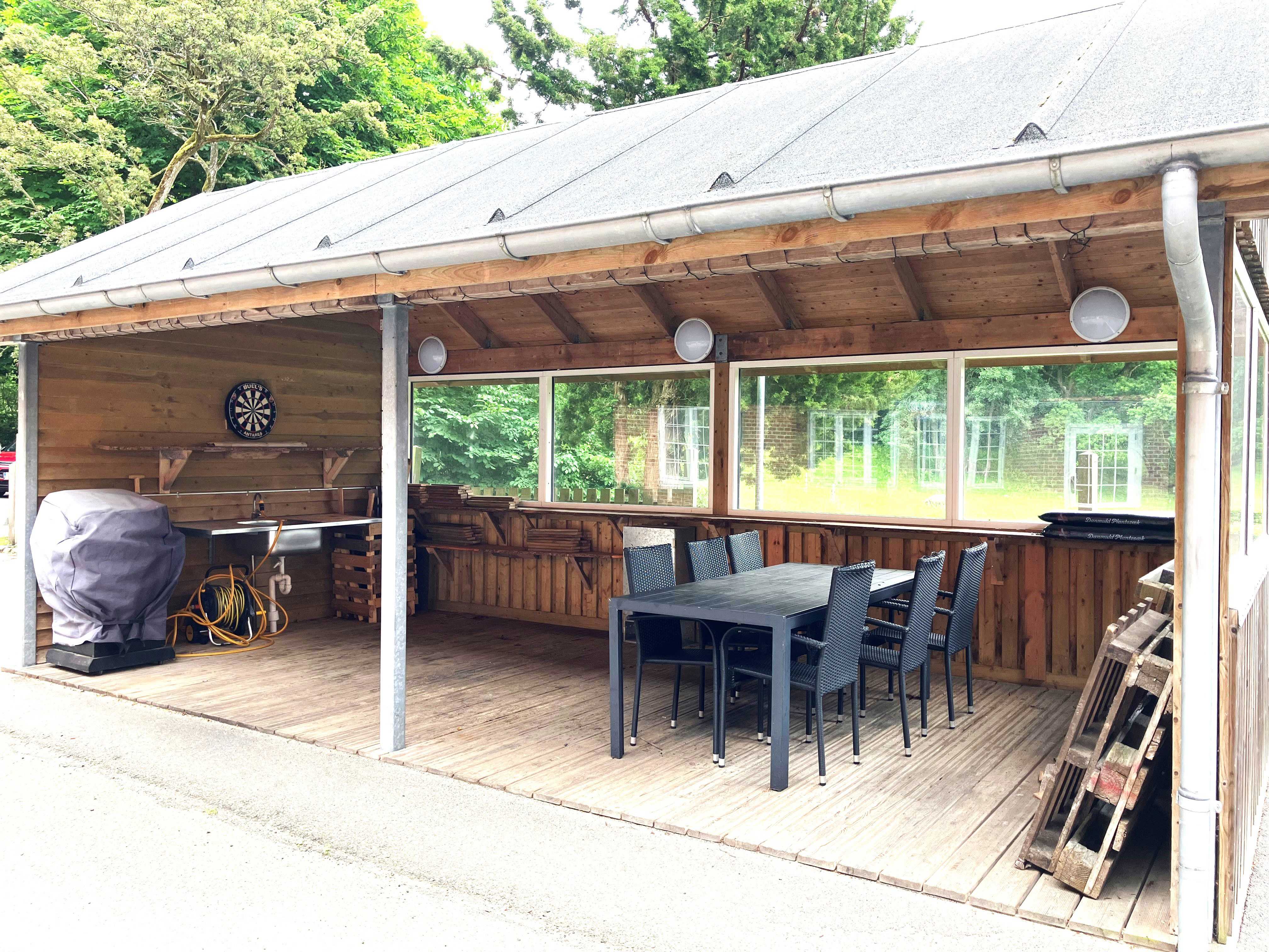 Overdækket udendørs terrasse med havemøbler